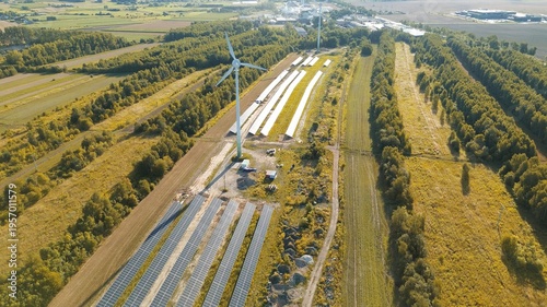 Foto Aerial view of wind turbine and solar panels in green landscape