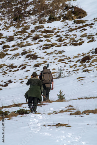 Obraz na plátne a hunter guy and a huntress are stalking on the mountains at a autumn day
