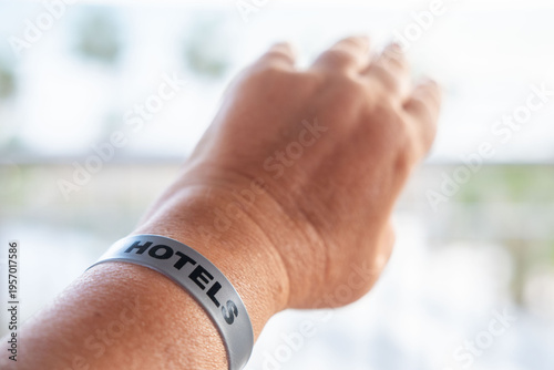 female hand adult beach vacation, wristband hotel resort identifier bracelet on beach, all inclusive vacation shared memories, travel summer holiday, identifier for resort access, security, or payment