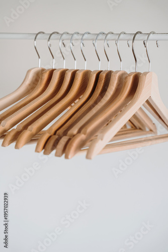 Blank Wooden Clothing Hangers Hanging In A Light Room