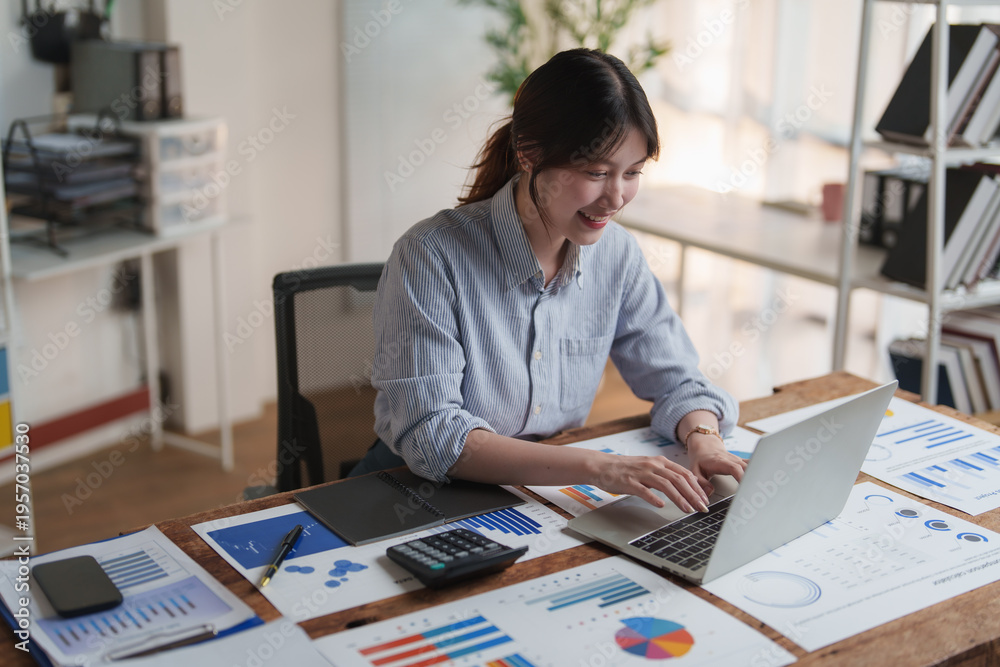 Fototapeta premium Happy young woman working on financial data analysis