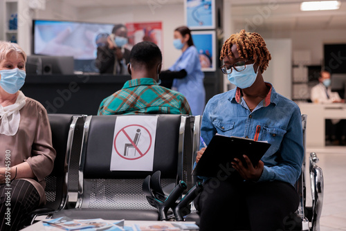 Quadro em tela African american patient with mobility problem filling out medical form to undergo tests