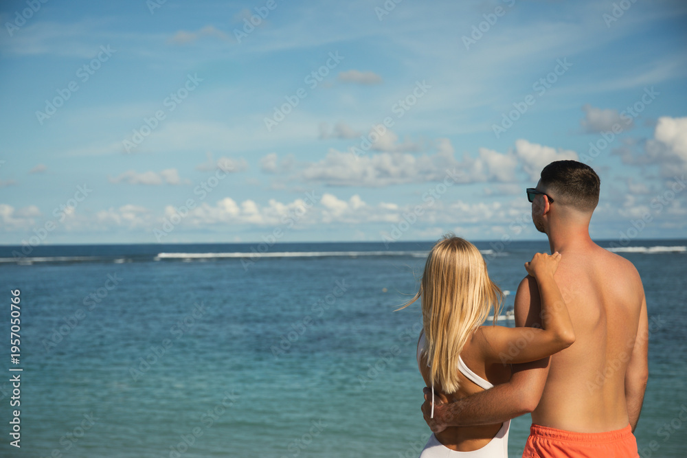 Fototapeta premium Couple looks at ocean waves from beach in Bali