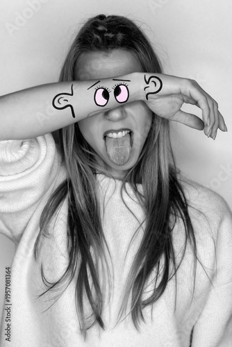Playful portrait with creative face drawing and tongue out gesture