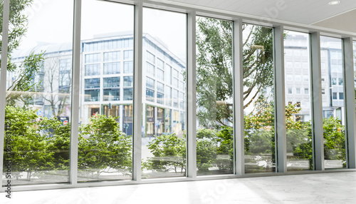 Modern hotel lobby with large windows plants and urban city view
