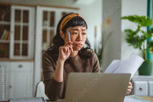 Photos Woman experiencing frustration compiling financial documents and calculations