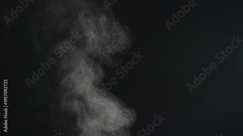 Slow motion steam rising from boiling water over black background
