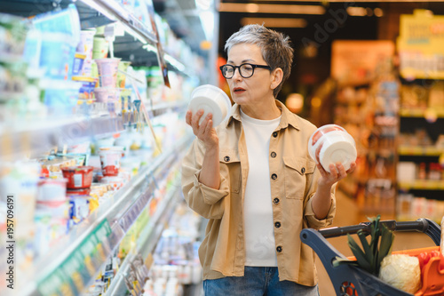 Konstfotografi Woman choosing dairy products at supermarket in aisle