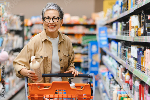 Fotografie Mature woman smiling buying products in supermarket