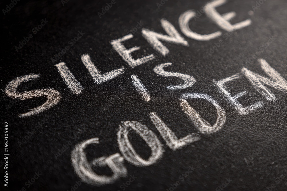 Fototapeta premium Handwritten chalkboard message: 'SILENCE IS GOLDEN' in elegant white script