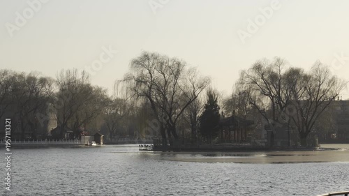 sundown landscape view of chinese architecture pavillion among island in chinese lake pond in chinese style in winter time at Shichahai Area,park with pond lake in chinese architecture style