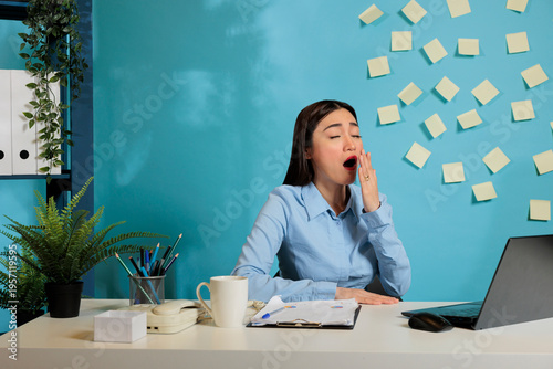 Foto Exhausted asian professional woman, yawning while working on project sitting at workstation