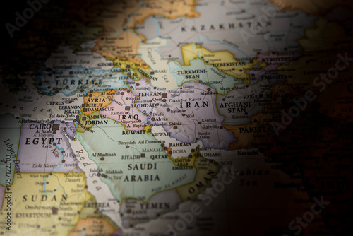 Dramatically lit world map focusing on Iran and the Middle East region, highlighting geopolitical hotspots and international borders in shadow