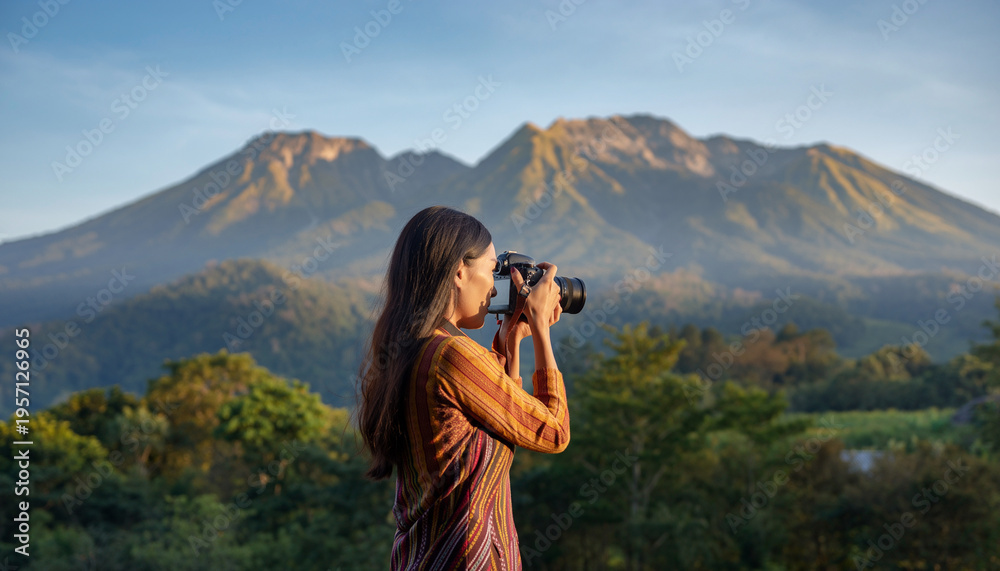 Obraz premium A woman takes a photo of mountains with a camera in a natural landscape.