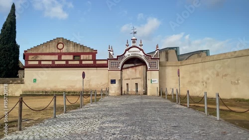 Cobblestone path leading to the historic main gate of the Real Fabrica de Tabacos, a tobacco factory in Seville, Spain