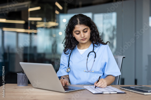 Fotografía Female healthcare worker researching medical data on laptop
