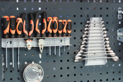 Obraz na plátně Organized tools hang neatly on gray pegboard