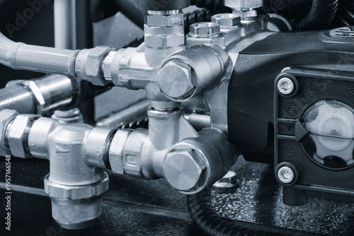 Industrial machine concept, industrial hydraulic machine with rubber and metal pipes high pressure pipes, real technical image.