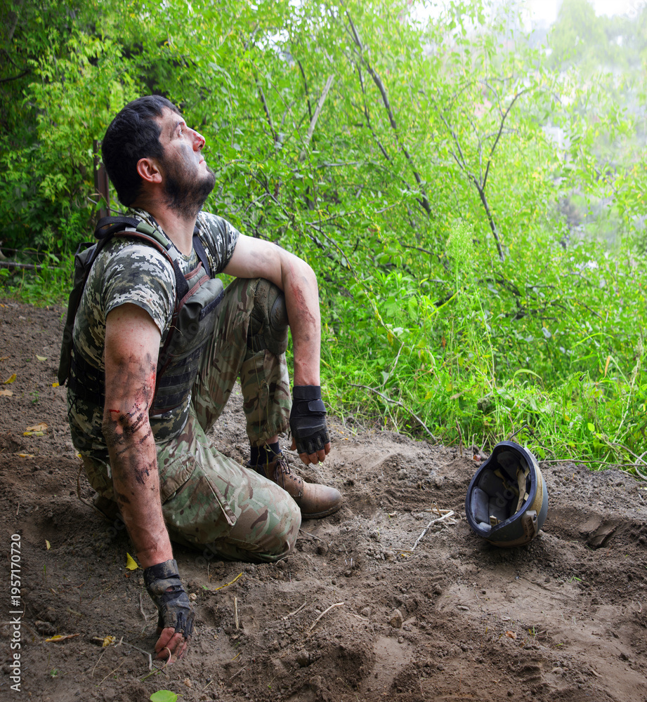 Fototapeta premium Young soldier sitting on the ground