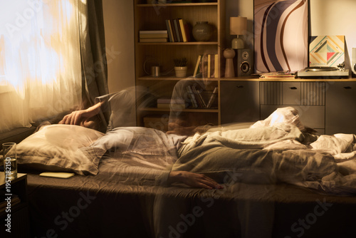 Photos Young woman lying in bed tossing and turning with blurred motion effect suggesti