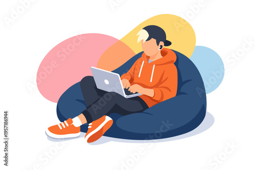Young man in orange hoodie using laptop while sitting on bean bag chair.