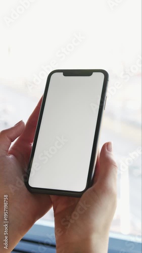A businessman's hand is holding a smart mobile phone with a blank digital touch screen display for business communication and technology message technology