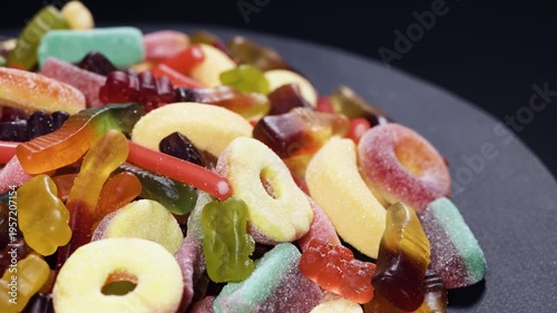 Tasty colorful jelly candies on dark stone plate.