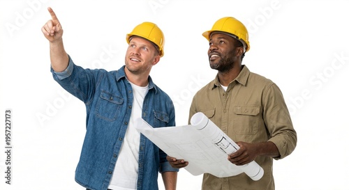 Two construction workers in yellow hard hats review blueprints, one pointing towards the sky, against a studio backdrop, teamwork and collaboration.