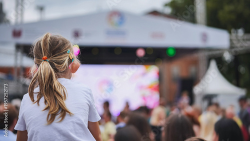 Little girl watching a concert on someone's shoulders