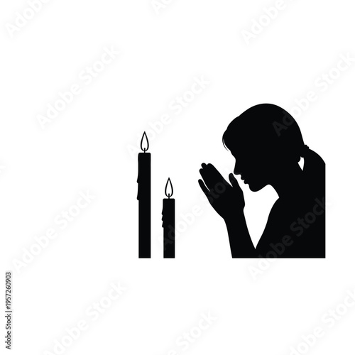 Silhouette of a woman praying with lit candles in a peaceful setting