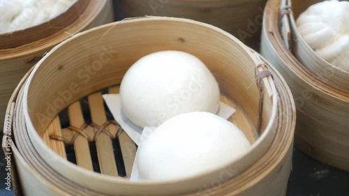 close up view to a steamer full with chinese bun dimsum in hongkong style with hot streaming ready to eat in panning view,chinese dimsum food eating