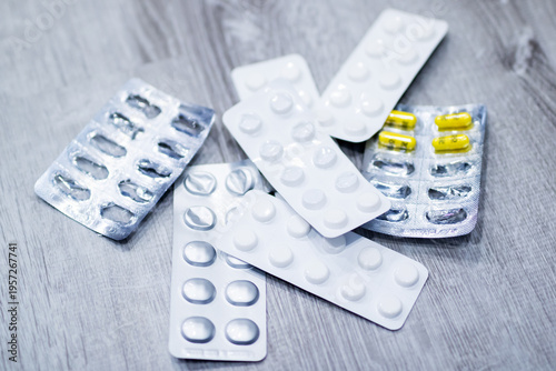 Detailed view of medicinal strips on wooden surface showcasing safety and healthcare themes