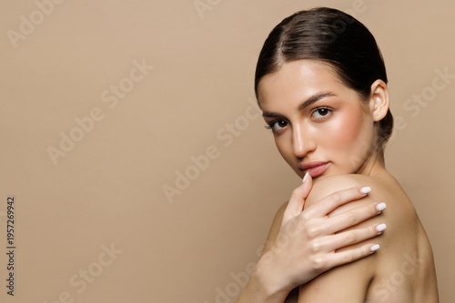 Beautiful young woman with clean fresh skin on beige background, Face care, Facial treatment, Cosmetology, women portrait.