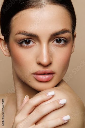Beautiful young woman with clean fresh skin on beige background, Face care, Facial treatment, Cosmetology, women portrait.