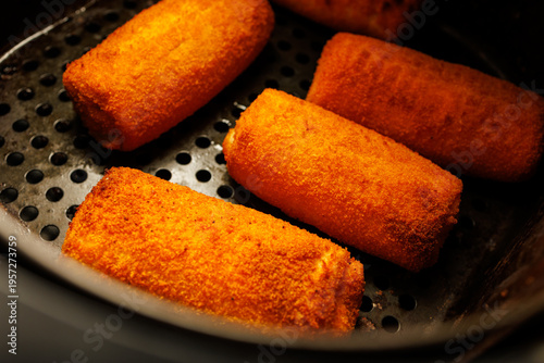 Bild auf Leinwand Crispy breaded rolls frying in pan, golden crunchy snack or appetizer close up