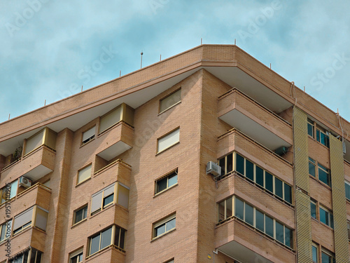 Modern red brick apartment building exterior, contemporary modern residential architecture in urban neighborhood in Valencia Spain