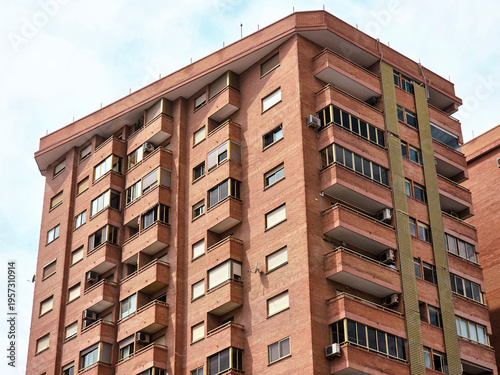 Modern red brick apartment building exterior, contemporary modern residential architecture in urban neighborhood in Valencia Spain