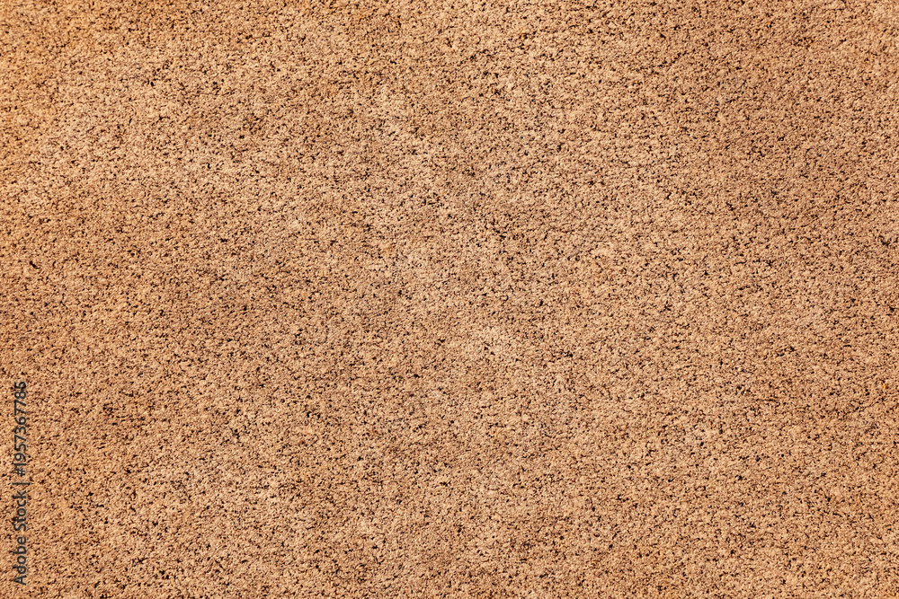 Fototapeta premium Natural stone wall texture featuring rough, porous surfaces and warm brown tones, suitable for architectural backgrounds and creative design use. Ideal for construction and industrial themes.
