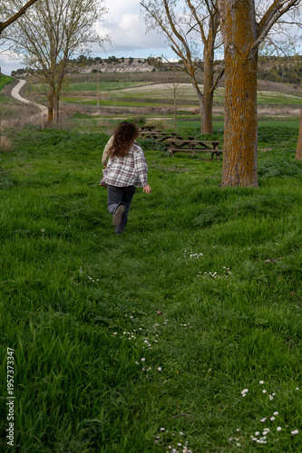 Woman running through green field in nature