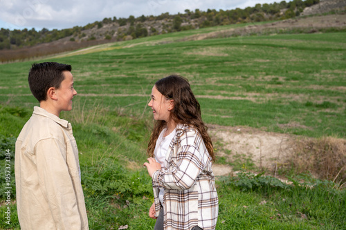 Children smiling talking outdoors in green field