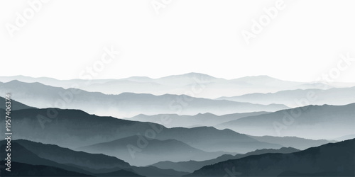 Misty blue mountain peaks and forest valleys under a soft sunset sky create a serene landscape of fog-covered hills at dawn.