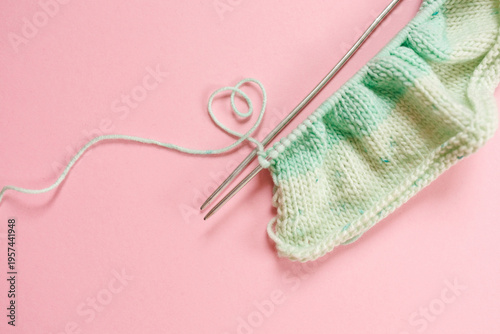 Minimal knitting composition with yarn and needles on pastel pink background DIY concept