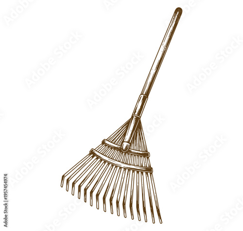 A brown rake with a long wooden handle and metal tines for gardening and yard work