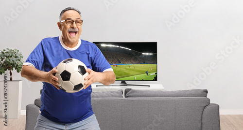 Happy man in a blue jersey holding a football