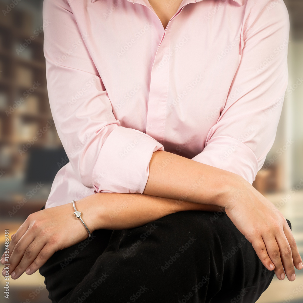 Obraz premium Partial view of business woman standing with visible arms against neutral shop or office background. Confidence, professionalism and modern business lifestyle. Copy space for text or product placement