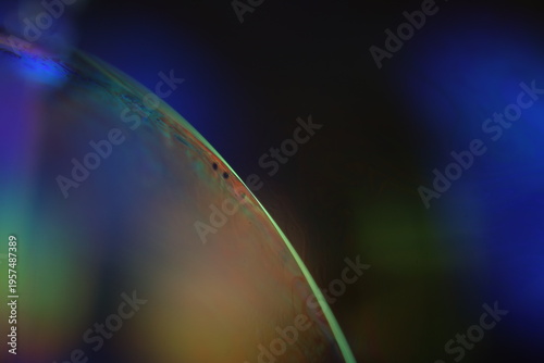 Abstract iridescent light refraction on curved glass surface macro background