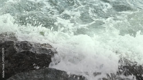 Real captured ocean waves hitting rocks on the shore. Natural environment, authentic footage, not AI generated. Ideal for nature, energy and marine concepts.