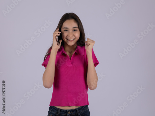 Young woman talking on a smartphone and smiling in the studio