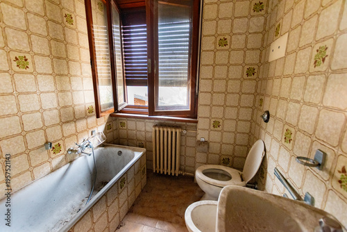 Obraz na płótnie Abandoned vintage bathroom with retro patterned tiles, old tiled bathtub, toilet