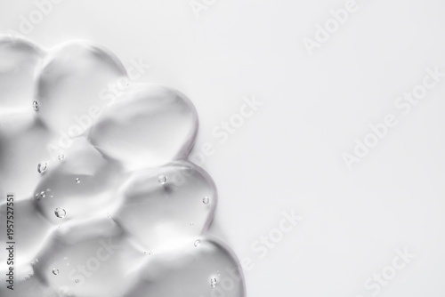 Clear cosmetic gel with bubbles creating dynamic texture on white background